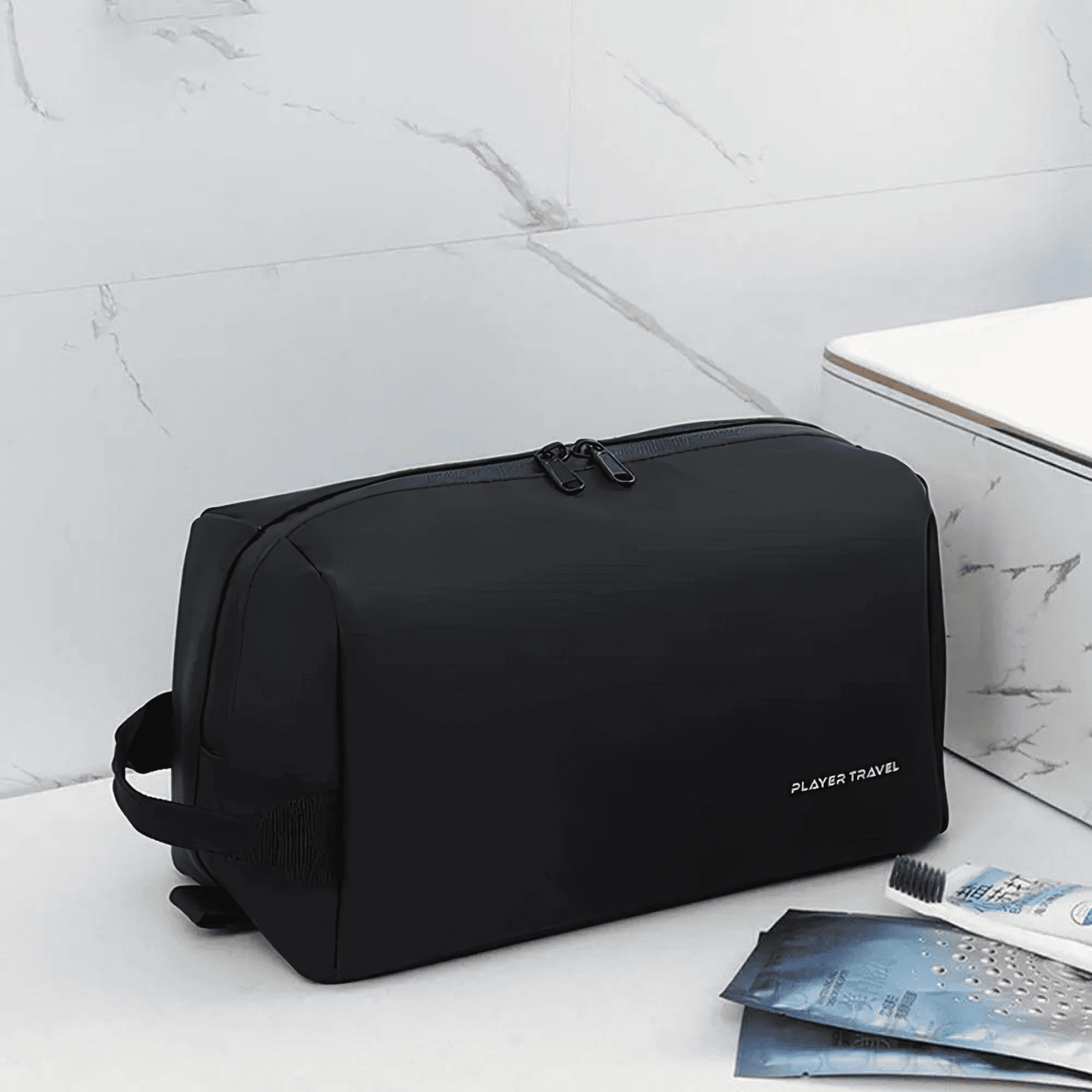 Trousse de toilette homme imperméable noire Player Travel posée près du lavabo, idéale pour la salle de bain.