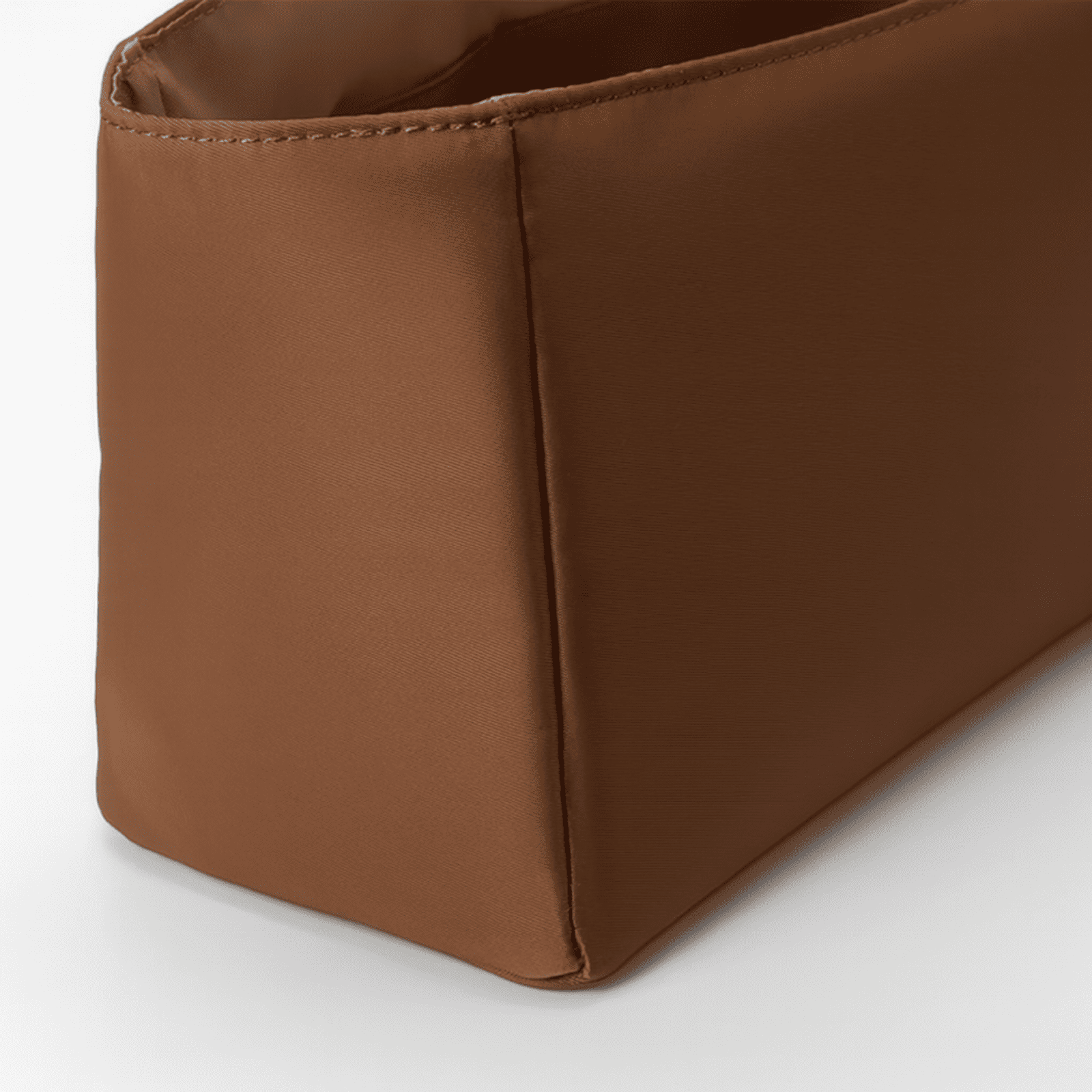 Zoom sur les détails et coutures de la trousse de toilette rigide marron