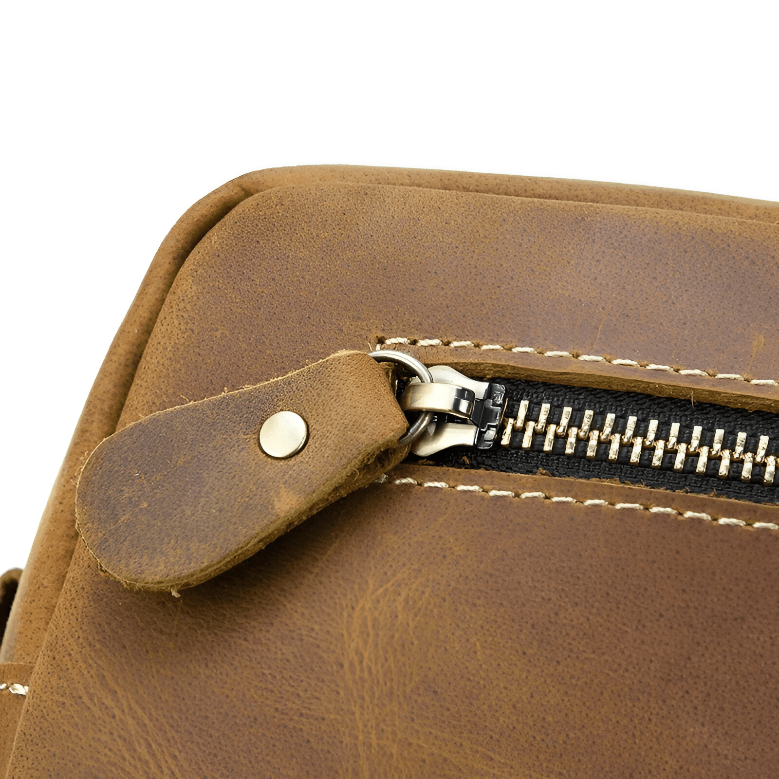 Gros plan sur la fermeture éclair et la tirette en cuir d’une trousse de toilette homme marron