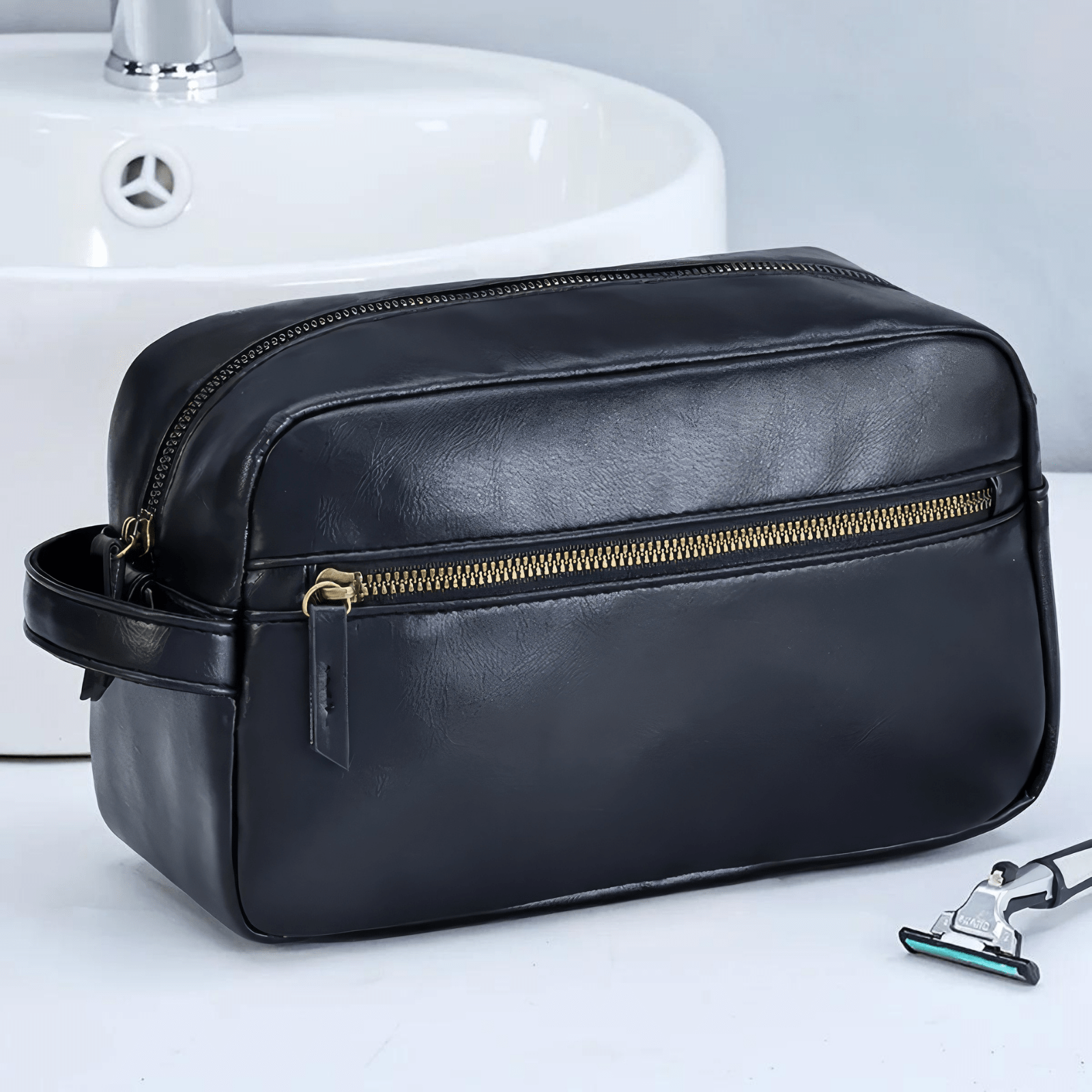 Trousse de toilette homme en simili cuir noir pour voyage posée près du lavabo
